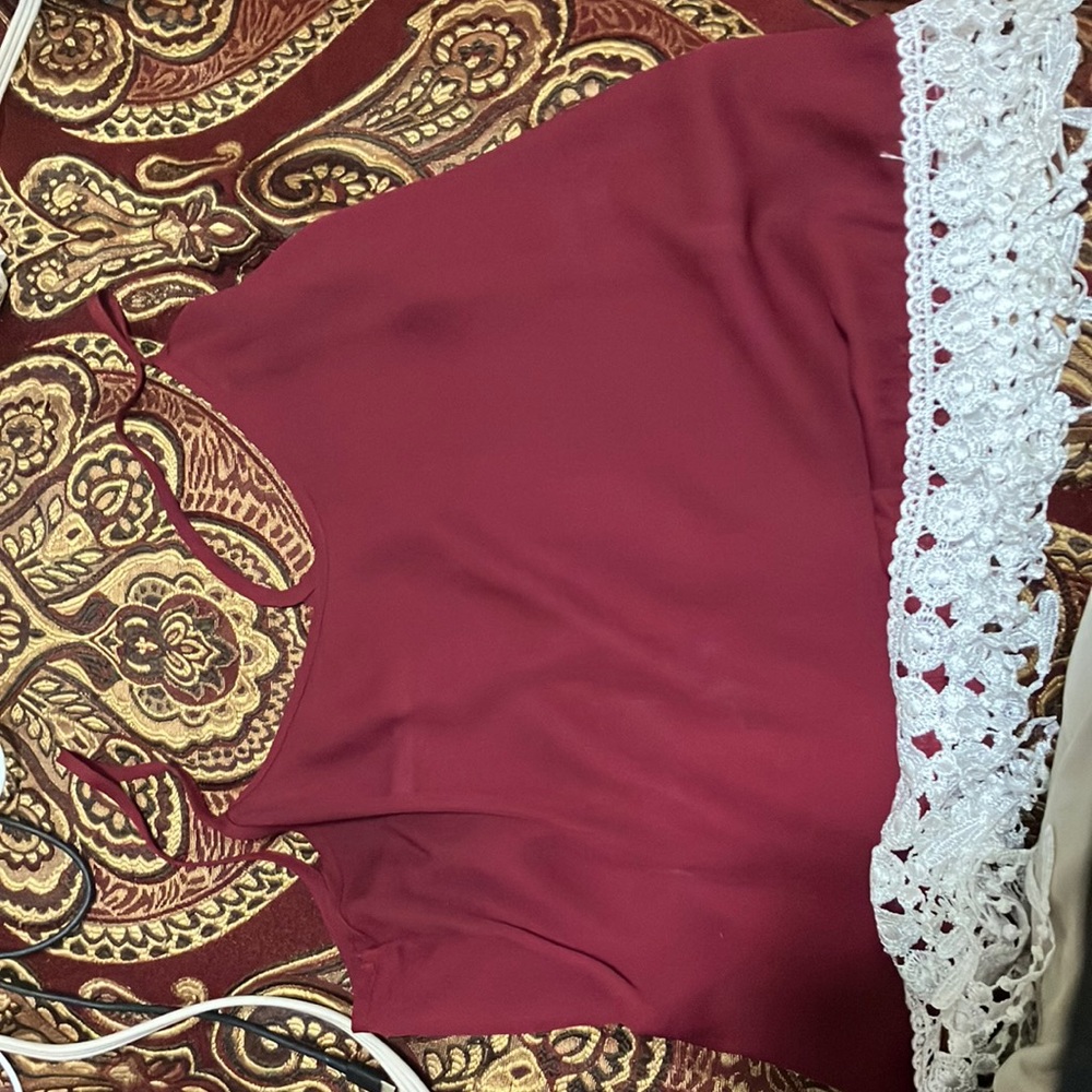 Fascination maroon thin strapped tank top with whit tassels on the bottom.